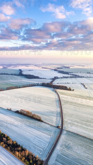 Bird Eye Perspective of Frost Covered Farmland. Seasonal Agricultural Scenery, winter and autumn scene, blue sky with golden light at sunrise, AI generated