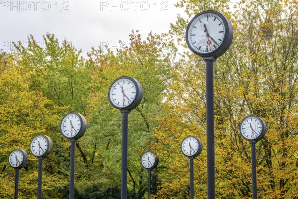 The art installation Zeitfeld in Volksgarten Park in Düsseldorf-Oberbilk, a total of 24 station clocks, on 6 meter high steel columns, have been running synchronously since 1987, artwork by Düsseldorf artist Klaus Rinke, symbol of time, time change, North Rhine-Westphalia, Germany
