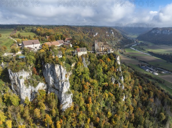 Aerial view of Werenwag Castle and former Werenwag Castle on a rocky spur in the Upper Danube Valley, surrounded by autumnal vegetation and clouds of fog, Sigmaringen district, Baden-Württemberg, Germany