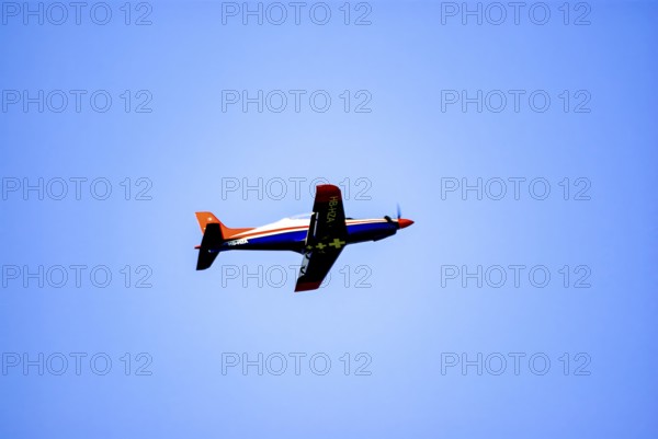 An RC model of a Pilatus PC-21 with advertising for the Swiss watch brand Breitling during a flight demonstration as part of an air show at the Rossfeld in Metzingen-Glems, Baden-Württemberg, Germany, for editorial use only