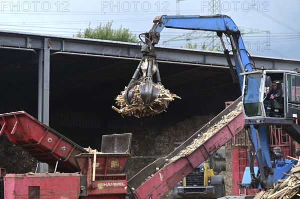 Loading crane with grab arm for loading wood waste for wood pellet production on the premises of Energie-Mann in the Westerwald. manufactured