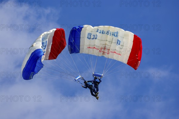 Two parachutists during an aerial acrobatic performance as part of an air show at the Rossfeld in Metzingen-Glems, Baden-Württemberg, Germany, for editorial use only
