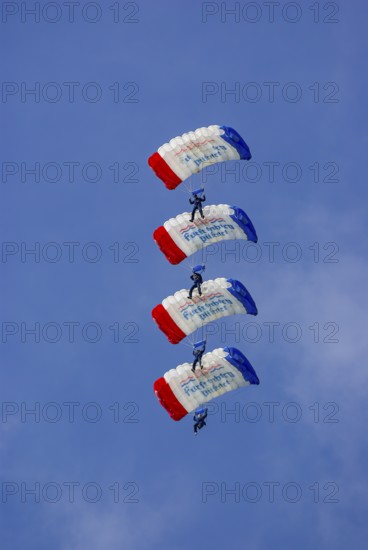Parachutists during an aerial acrobatic demonstration as part of an air show on the Rossfeld in Metzingen-Glems, Baden-Württemberg, Germany, for editorial use only