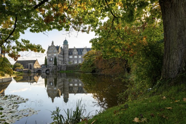 View across the castle pond to Hämelschenburg Castle, a moated castle and major work of the Weser Renaissance, near Emmerthal, Weserbergland, Lower Saxony, Germany