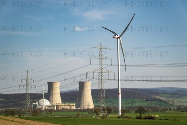 Distant view of the Grohnde nuclear power plant, with wind turbine, electricity pylons and power lines in the foreground, Emmerthal, Lower Saxony, Germany