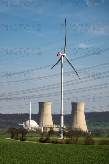 Distant view of the Grohnde nuclear power plant, dominated by a wind turbine, power lines in the foreground, Emmerthal, Lower Saxony, Germany