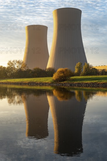 The cooling towers of the Grohnde nuclear power plant in the morning light reflected in the Weser, Emmerthal, Lower Saxony, Germany