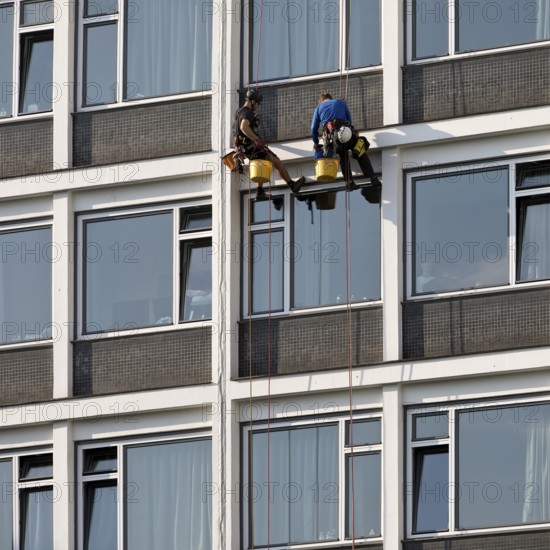 Two male glass cleaners abseiling down the hotel façade to clean windows, aletto Hotel Kudamm, Berlin, Germany