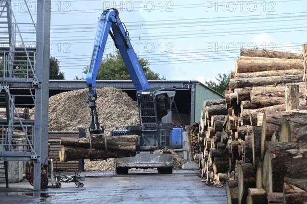 Wood storage and mechanical log transport on the premises of Energie-Mann in the Westerwald. Wood pellets are produced there