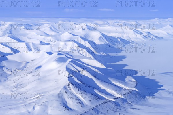 Aerial view over snow-covered mountains and valleys on Svalbard, Spitsbergen in spring, Norway