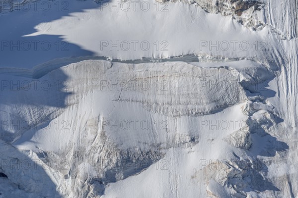 Intricate patterns of ice and rock are showcased in this stunning glacial landscape, revealing the effects of time on the frozen surface. The bright daylight emphasises the textures and colours. Gorner Glacier, Zermatt, Valais, Alps, Swiss