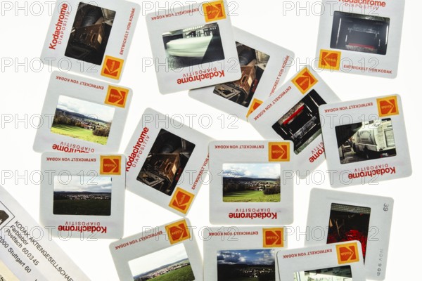 Many framed Kodachrome slides on a light table with magnifying glass, top shot