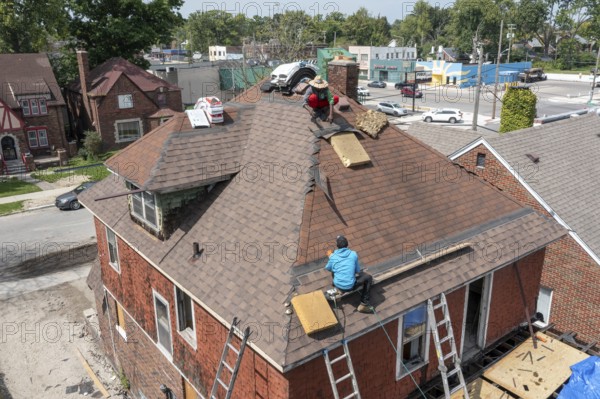 Detroit, Michigan - Workers re-roof a house they are remodeling in the Morningside neighborhood that had been vacant for many years. Detroit lost nearly two-thirds of its residents from 1950 to 2020 but has been growing modestly in recent years