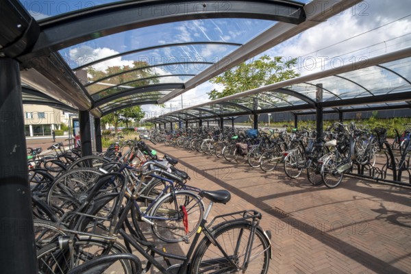 Bicycle parking spaces and boxes on the cycle path in the east of Utrecht, at Utrecht-Lunetten railway station, direct connection of the cycle path to the railway station and bus station, covered bicycle stands, on the Maarschalkerweerdpads cycle path, Netherlands