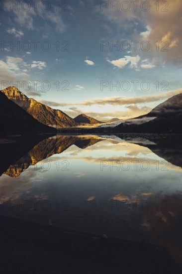 Sunrise with reflections in Lake Heiterwanger See in Tyrol in the Alps in Austria