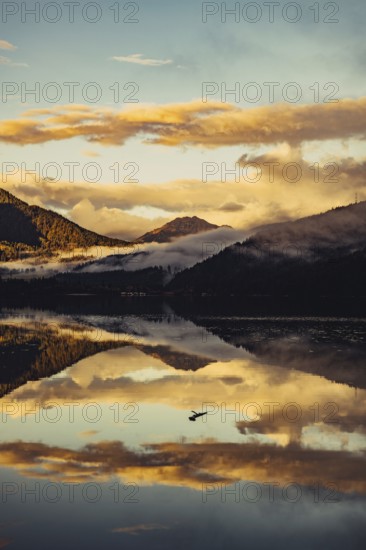 Sunrise with reflections and alpenglow in Lake Heiterwanger See in Tyrol in the Alps in Austria