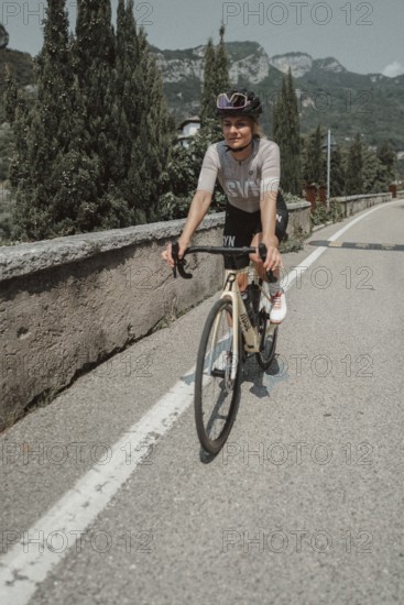 Young woman riding a racing bike on Lake Garda. Sunny weather and dolce vita