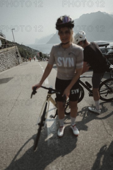 Woman and man riding racing bikes in Italy on Lake Garda