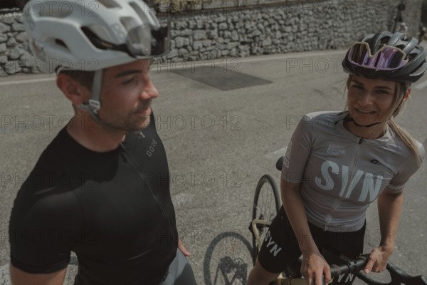 Woman and man cycling on Lake Garda in Italy. Sunny weather and dolce vita