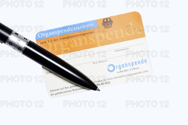 Organ donor card with biros on white background, symbolic image of organ donation