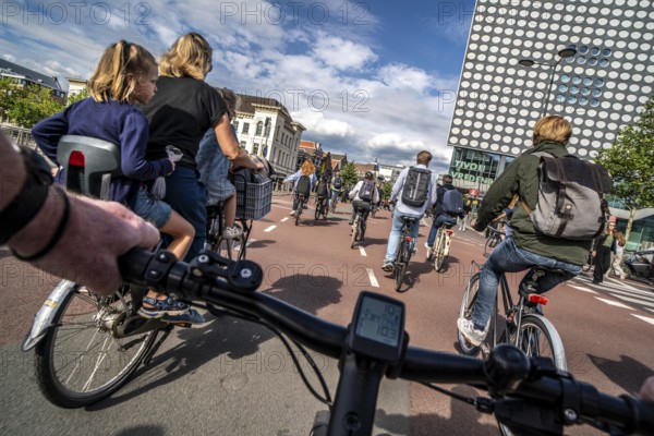 Ride your bike on the central cycle path on Lange Viestraat, Vredenburg, in the city centre of Utrecht, lanes for pedestrians, cyclists and public transport vehicles are separated, heavy cycle traffic, Netherlands