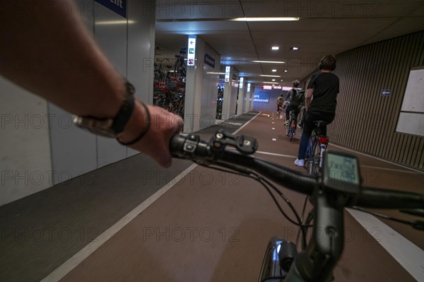 Ride your bike into and out of the bicycle car park at Utrecht Centraal station, Stationsplein, over 13, 000 parking spaces, considered the largest bicycle car park in the world, over 3 underground floors, Utrecht, Netherlands