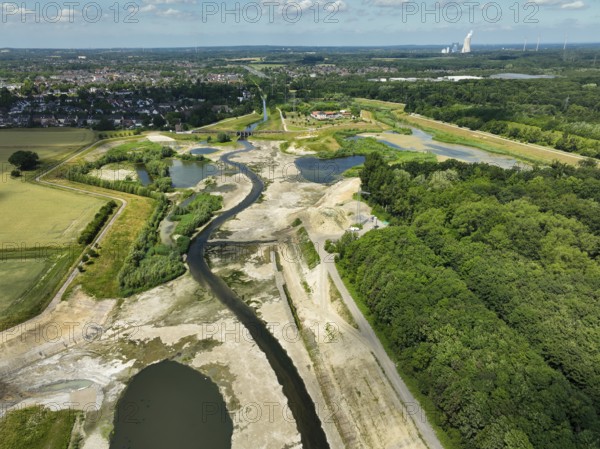 Dortmund, Castrop-Rauxel, North Rhine-Westphalia, Germany - River renaturalisation, renaturation of the Emscher, flood retention basin HRB Mengede. A new floodplain landscape is being created at the Emscher-Auen farm, expanding the area for flood protection during heavy rainfall and for biodiversity. The previously straightened Emscher is being given curves again and can meander through its new floodplain. Following the construction of a parallel sewer, the Emscher has been completely free of sewage since 2022. The river was previously an open, above-ground mixed water channel with rainwater and wastewater. At the back right, the Uniper coal-fired power plant Datteln 4 power station