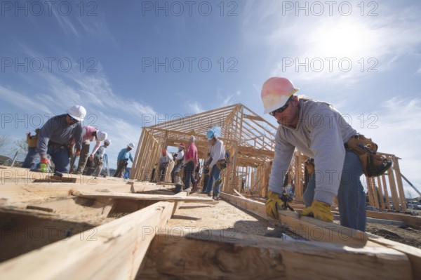 Collage of construction workers building homes, AI generated