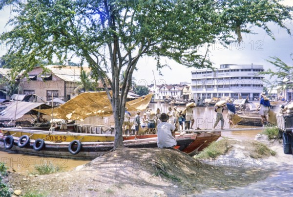 Unloading sacks from cargo boat on Singapore River, Singapore, southeast Asia c 1963 Sime Darby Ltd Godown warehouse in background