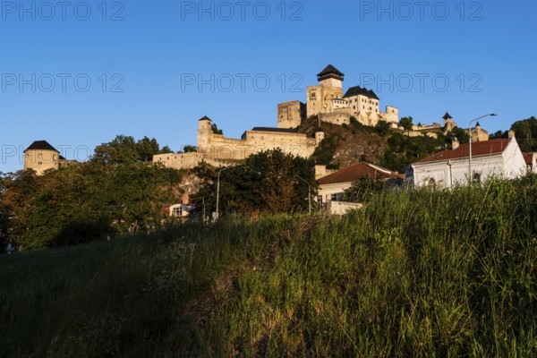 View of the castle and town of Trencín from the riverbank in the evening light, Capital of Culture 2026, Trencín, Slovakia