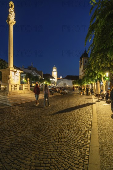 Night shot of the plague column column commemorating the victims of the plague at the beginning of the 18th century, in the background is Trencín Castle, Capital of Culture 2026, Trencín, Slovakia