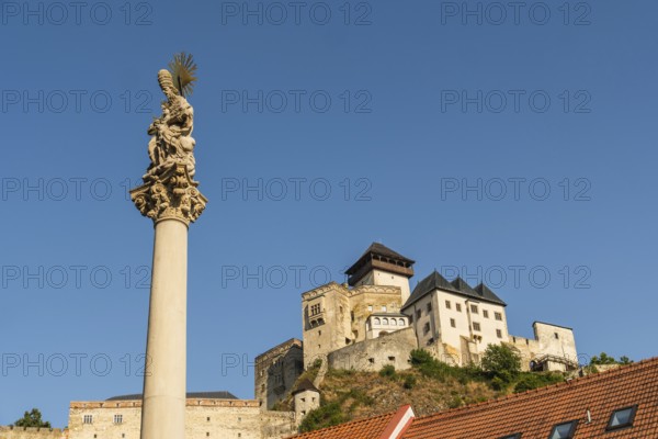 Plague column commemorating the victims of the plague column at the beginning of the 18th century, in the background is Trencín Castle, Capital of Culture 2026, Trencín, Slovakia