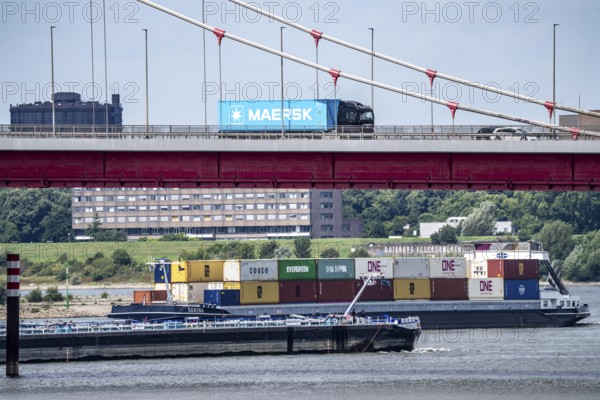 Barges on the Rhine at Ruhrort harbour, container freighter on uphill journey, Friedrich-Ebert-Bridge, road bridge over the Rhine between Homberg and Ruhrort, Maersk container on lorry on the bridge, Duisburg, North Rhine-Westphalia, Germany