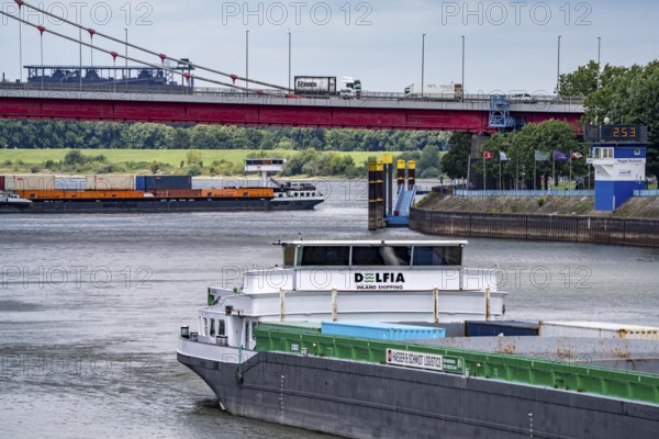 Barge enters the Vinckekanal, in the harbour of Ruhrort, container freighter on the Rhine, on an uphill journey, Friedrich-Ebert-Bridge, road bridge over the Rhine between Homberg and Ruhrort, Thyssenkrupp Steel steelworks, Duisburg, North Rhine-Westphalia, Germany