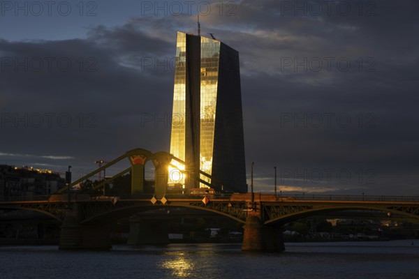 The light of the setting sun is reflected on the glass façade of the European Central Bank (ECB) in Frankfurt am Main, Frankfurt am Main, Hesse, Germany