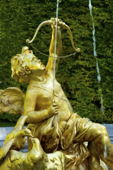 Fountain figure of Cupid, god of love, in gold with bow and arrow, Rococo style, east parterre, park of Linderhof Castle, UNESCO World Heritage Site, Ettal, Unterammergau, Garmisch-Partenkirchen, Upper Bavaria, Bavaria, Germany
