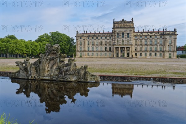 Ludwigslust Palace, built in the Baroque period and characterised by Classicism, with the palace square. In the foreground is the basin, a water basin with cascades and stone figures. Ludwigslust, Mecklenburg-Western Pomerania, Germany