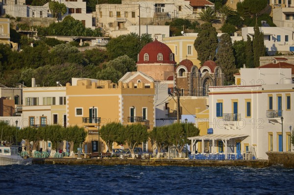 Colourful houses on the waterfront with a church and trees, Greek coastal town ambience, Agia Marina, Leros, Dodecanese, Greek Islands, Greece
