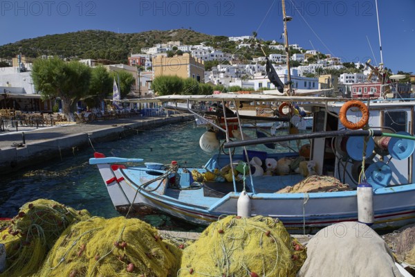 Fishing boats in the harbour of a Greek village, surrounded by fishing nets and blue sky, Agia Marina, Leros, Dodecanese, Greek Islands, Greece