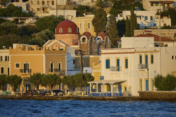 Colourful coastal houses with church and trees by the water, sunny city panorama, Agia Marina, Leros, Dodecanese, Greek Islands, Greece