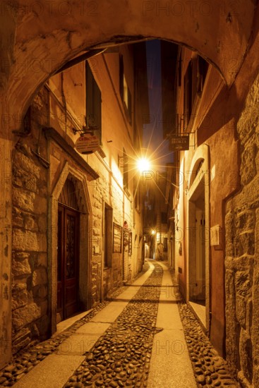 Alley illuminated at night, old town centre, Orta San Giulio, on Lake Orta, Province of Novara, Piedmont, Italy