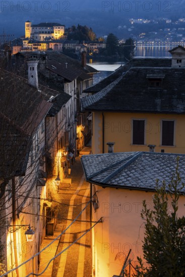 Illuminated alley with view of Isola San Giulio, Orta San Giulio, on Lake Orta, Province of Novara, Piedmont, Lago d'Orta, Italy