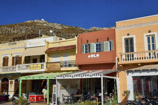 Colourful shops and cafés along a shopping street under a bright blue sky, Agia Marina, Leros, Dodecanese, Greek Islands, Greece