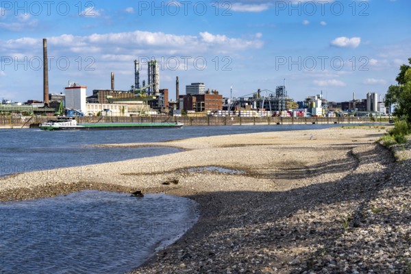 Low water of the Rhine near Leverkusen, Rhine bank, left bank of the Rhine, near Cologne-Merkenich, opposite Chempark Leverkusen, cargo ship on the Rhine, extremely low water level, no restrictions on inland navigation yet, North Rhine-Westphalia, Germany