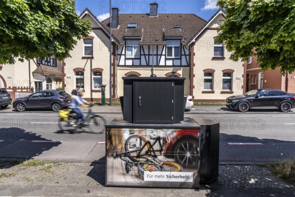 Semi-stationary speed camera in Nobelstraße, in the Wiesdorf district of Leverkusen, Bayer AG's Werkssiedlung II, heritage-protected building, used by the city of Leverkusen, model TraffiStar S350, semi-station V3, from Jenoptik, the device is temporary, self-sufficient for up to a week, at various measuring points, can measure and flash in 2 directions, laser measuring technology, data is sent to the city via mobile radio, is installed on a protected trailer, also known as an armoured speed camera, here a 30km/h zone, North Rhine-Westphalia, Germany