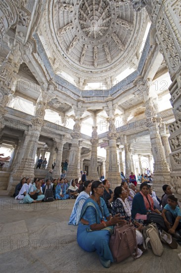 Indian woman praying between the white marble pillars in the Adinath temple in Ranakpur, Jain temple, Rajasthan, India