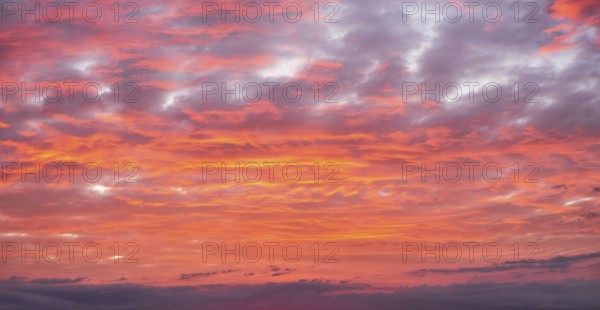 Background image for sky replacement, evening sky with illuminated red clouds at dusk after sunset