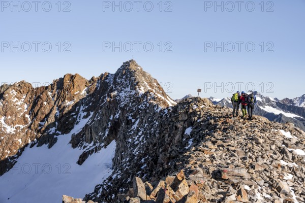 Mountaineer on a ridge, in the background summit Wilder Freiger with summit cross, Stubai Alps, South Tyrol, Italy