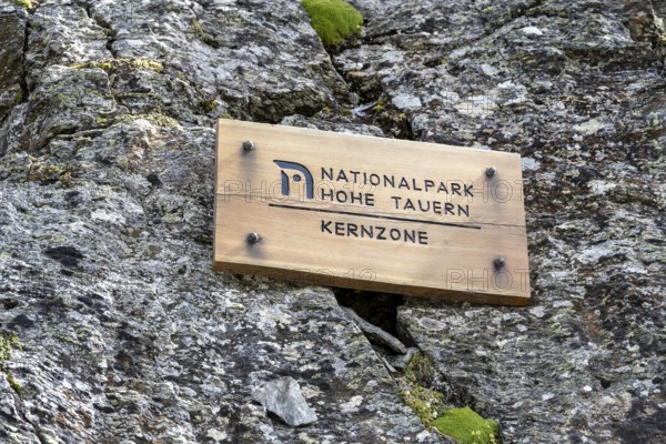 Wooden sign on rock, inscription Hohe Tauern National Park core zone, Schober group, Hohe Tauern National Park, Carinthia, Austria