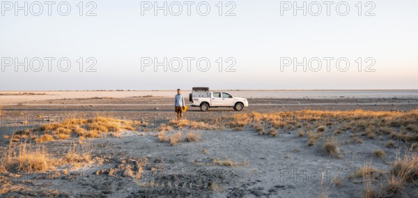 Tourist with off-road car exploring dry landscape, Kubu Island (Lekubu), Sowa Pan, Makgadikgadi salt pans, Botswana